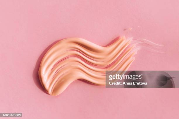 textured smear of tone cream on pink background. trendy products of the year. health and wellness concept - concealer stock pictures, royalty-free photos & images