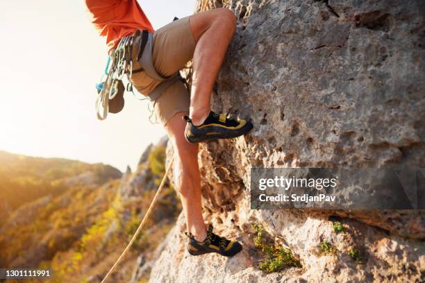 an unrecognizable man climbing - bota de alpinismo imagens e fotografias de stock