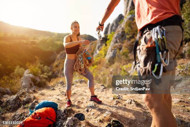 junge kletterer bereiten karabiner auf einem sicherheitsseil zum klettern vor - freiklettern stock-fotos und bilder