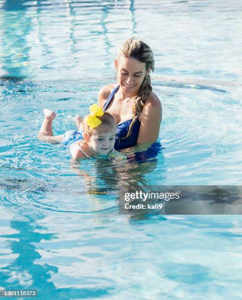 mutter mit baby-mädchen im schwimmbad - baby swimmer stock-fotos und bilder