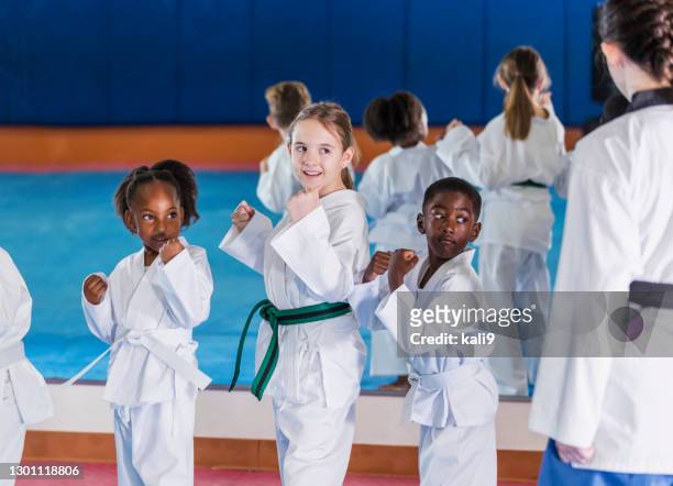 children taking taekwondo class with instructor - martial arts stock pictures, royalty-free photos & images
