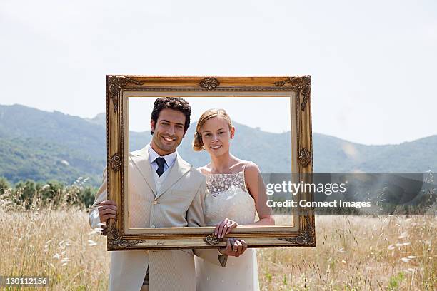 newlyweds holding vintage picture frame - just married frame stock pictures, royalty-free photos & images