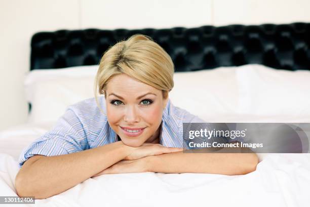 femme blonde allongée sur lit - allongé sur le devant photos et images de collection