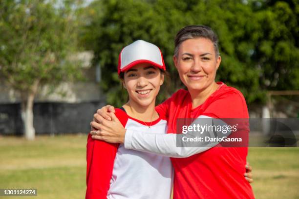 portret van tienerspeler met haar moeder, op het honkbalgebied - baseball mom stockfoto's en -beelden