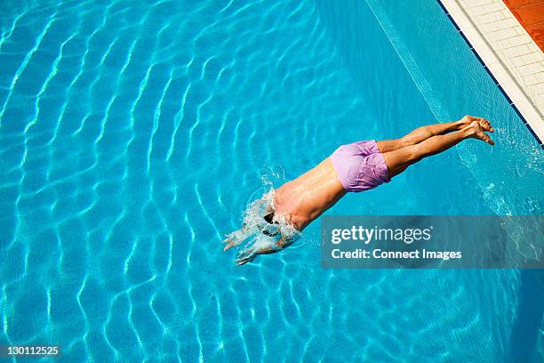 young man diving en la piscina - lanzarse al agua fotografías e imágenes de stock