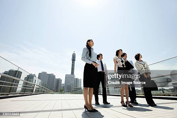 businesspeople in city scene - group of businesspeople standing low angle view stock pictures, royalty-free photos & images