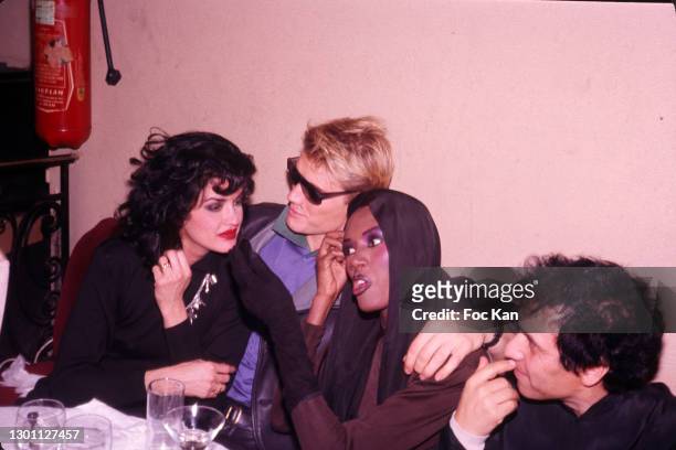 Guest, Dolf Lundgren, Grace Jones, and Designer Azzedine Alaia attend Alaia's Dinner Party in her honor at Le Palace Club on 1986 in Paris, France.