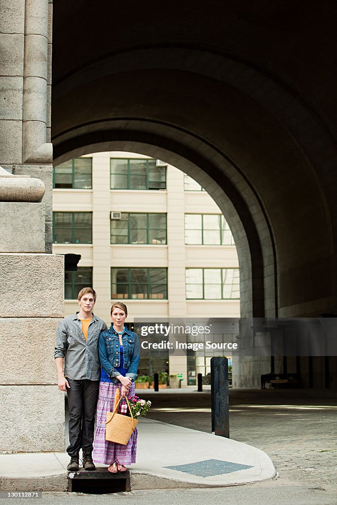 Young couple standing on city sidewalk
