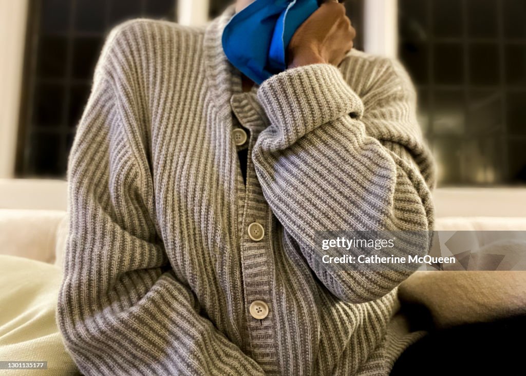 African-american woman holding heating pad to neck
