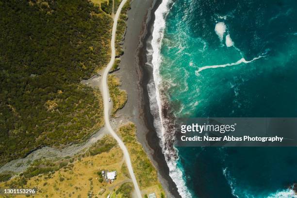 aerial view of road passing next to coast. - marine environment stock pictures, royalty-free photos & images