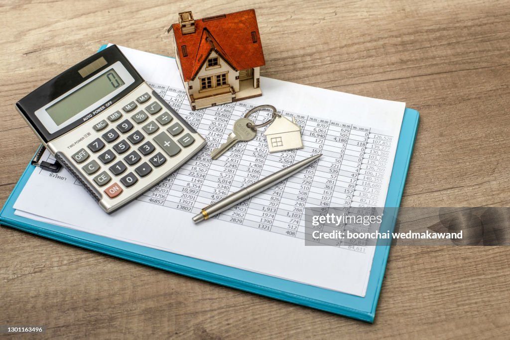 Closeup of house model and keys on wooden table