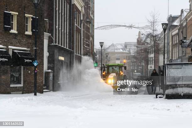 tractor clearing the streets of snow with a snow plow and brush - snow removal stock pictures, royalty-free photos & images