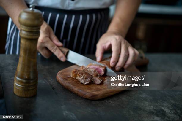 a pair of hands were cutting up the steak - pork cuts stock pictures, royalty-free photos & images