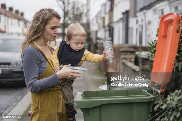 responsible british mother teaching toddler how to recycle - lixeira para lixo reciclável imagens e fotografias de stock