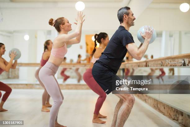 a female teacher conducts a barre fitness class. - pilates stock pictures, royalty-free photos & images