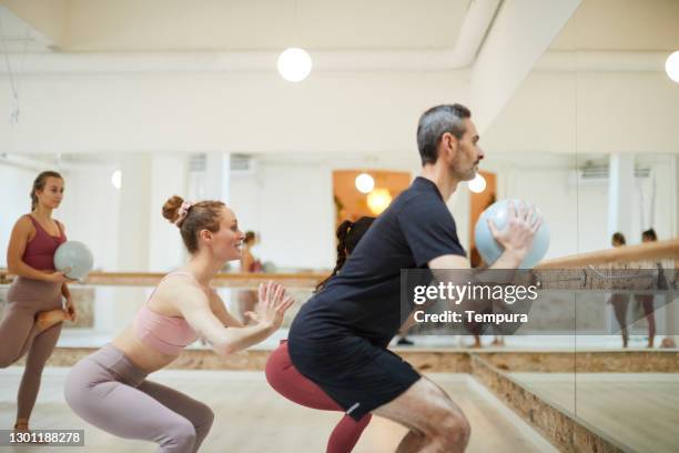 un hombre de mediana edad en una clase de fitness barre. - barre class fotografías e imágenes de stock