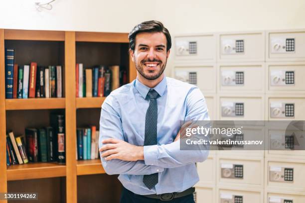 manager of a luxury hotel facing camera smiling with arms crossed - bank manager imagens e fotografias de stock