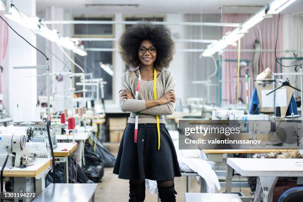 portrait of african fashion designer with measure tape in factory - woman tailor stock pictures, royalty-free photos & images