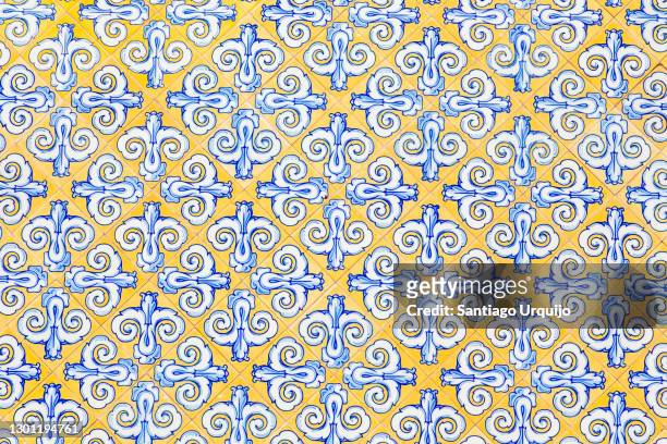 yellow and blue tiles on a wall - ceramic designs stockfoto's en -beelden
