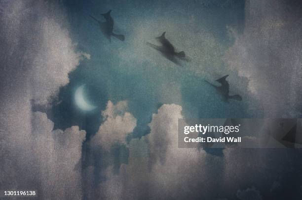 three witches flying on broomsticks. silhouetted against the night sky. surrounded by clouds. with a vintage, grunge edit. - bruxa imagens e fotografias de stock