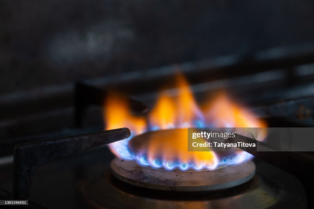 Closeups of a natural gas stove flame on dark background