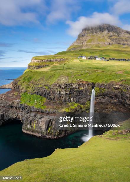scenic view of waterfall against sky,faroe islands,denmark - îles féroé photos et images de collection