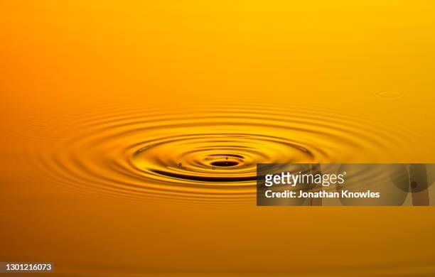 orange water ripple - water surface fotografías e imágenes de stock
