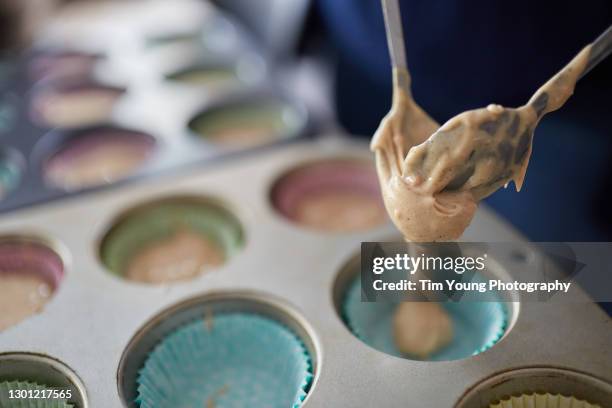 cake mixure being spooned into a cupcake case - cake batter stock pictures, royalty-free photos & images