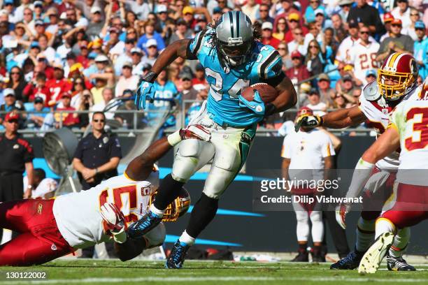 DeAngelo Williams of the Carolina Panthers slips out of a tackle by London Fletcher of the Washington Redskins at the Bank of America Stadium on...