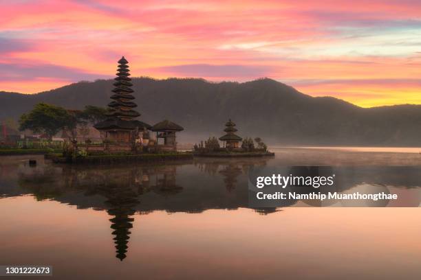 beautiful scenery of pura ulun danu bratan shows beautiful ancient of temple building under the colorful sky of sunset located in bali, indonesia. - pura ulu danau temple stock pictures, royalty-free photos & images