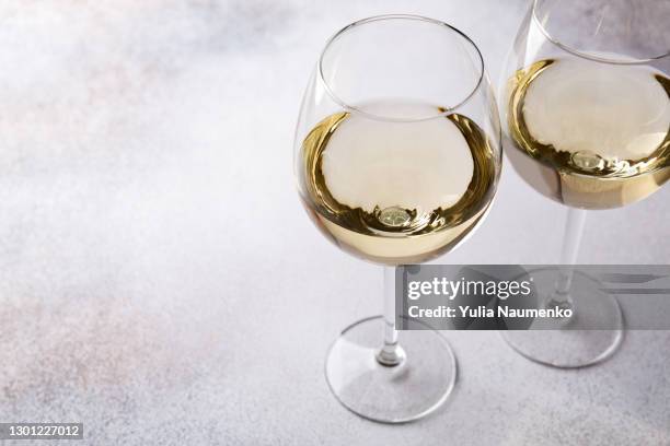 glasses of white wine on table - vin champagne imagens e fotografias de stock