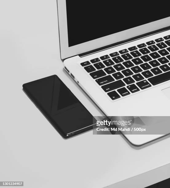 high angle view of laptop on table - black and white smartphone stock pictures, royalty-free photos & images