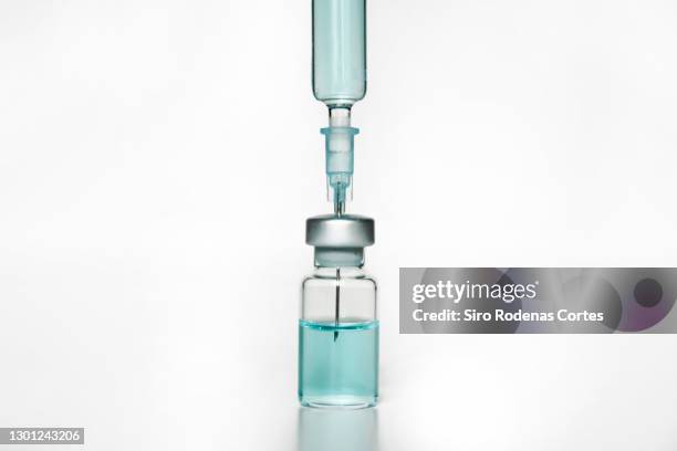 syringe inserted into a vial - liquid medical stock-fotos und bilder