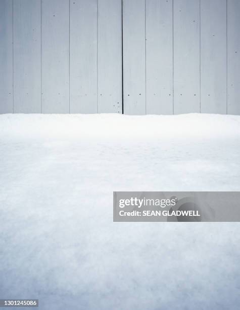 snowdrift by wooden doors - deckenverkleidung holz stock-fotos und bilder