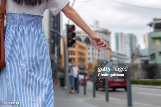 irresponsibly throwing off used face mask on the street - dirty women pics stock pictures, royalty-free photos & images