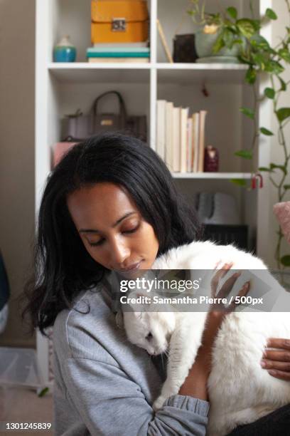 african american woman holding white short haired domestic cat,toronto,ontario,canada - black and white cat foto e immagini stock