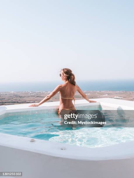 de vrouw overweegt santorini van haar jacuzzi - cyclades islands stockfoto's en -beelden