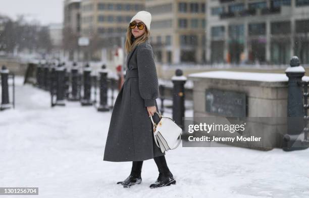 Sonia Lyson wearing Fendi grey dress and grey coat, white leather Fendi Peekaboo bag, Fendi Shades and Zara boots on February 09, 2021 in Berlin,...