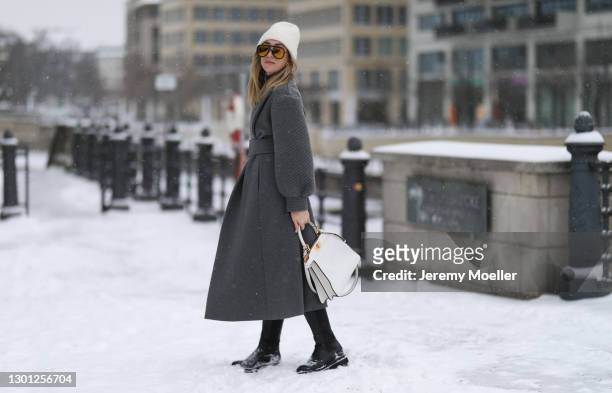 Sonia Lyson wearing Fendi grey dress and grey coat, white leather Fendi Peekaboo bag, Fendi Shades and Zara boots on February 09, 2021 in Berlin,...