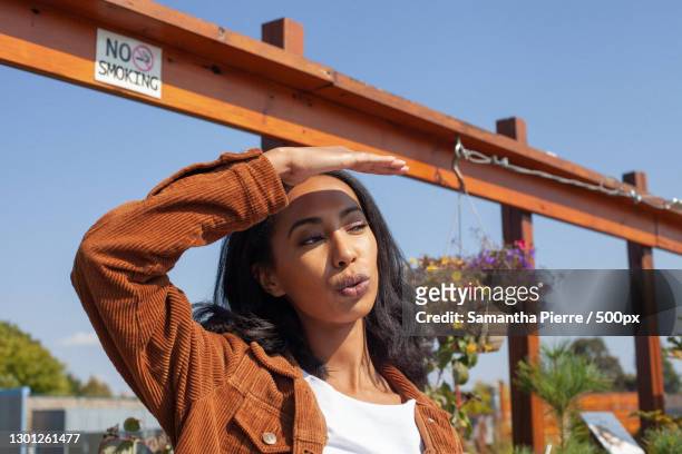 african american woman squinting and looking away from camera outside,toronto,ontario,canada - entrecerrar los ojos fotografías e imágenes de stock
