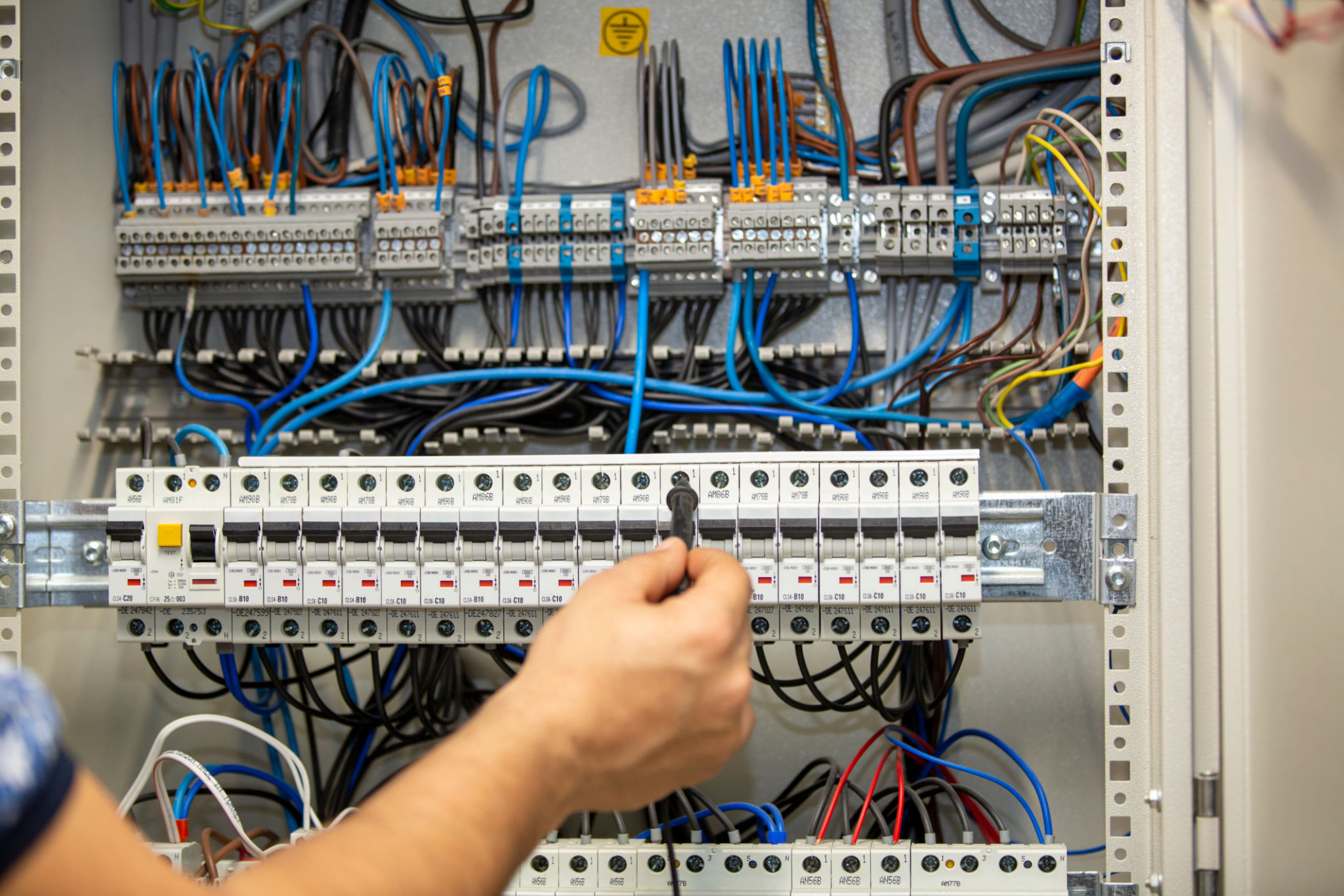 Electrician working at electric panel Electrician working at electric panel