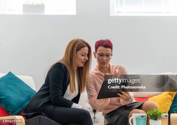 kolleginnen mit spaß in der kaffeepause diskutieren ideen genießen freizeit zusammen mit digitalen tablet - unterhaltungsberuf stock-fotos und bilder