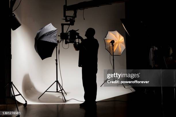 camera operator working behind the scenes while filming on a film set - camera operator imagens e fotografias de stock