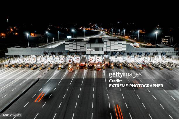 vista aerea dei droni sul punto di raccolta dei pedaggi in autostrada di notte. - pedaggio foto e immagini stock