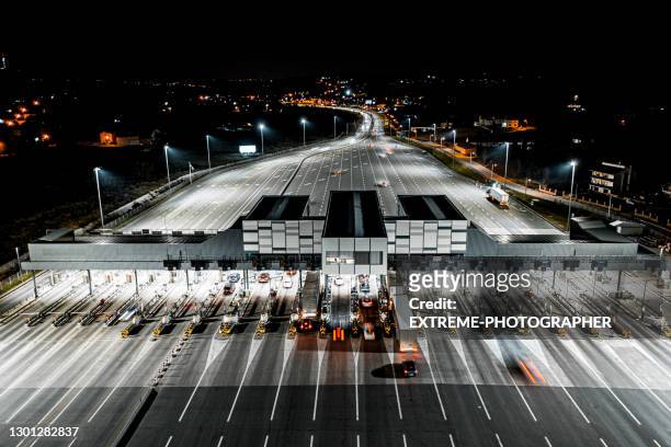 pay toll collection point on motorway at night seen from a drone - toll stock pictures, royalty-free photos & images