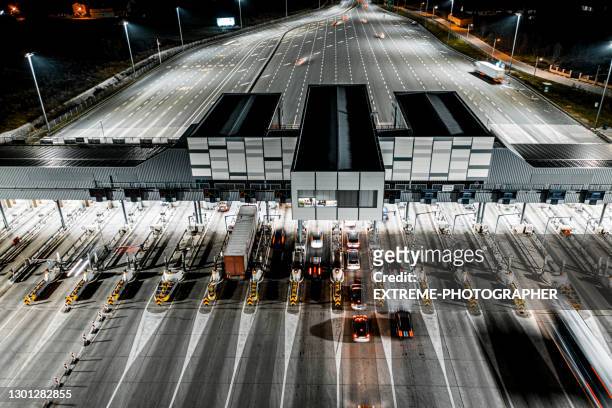 toll booth seen at night from a drone perspective - tolls stock pictures, royalty-free photos & images