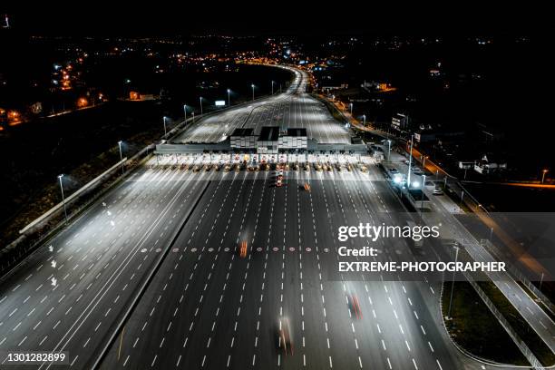 paga stazione a pedaggio in autostrada di notte vista da un elicottero - pedaggio foto e immagini stock