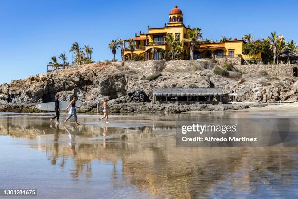 Surfer walks with two friends along the beach of "Los Cerritos" as part of the sport activities practiced in the town of Todos Santos on February 8,...
