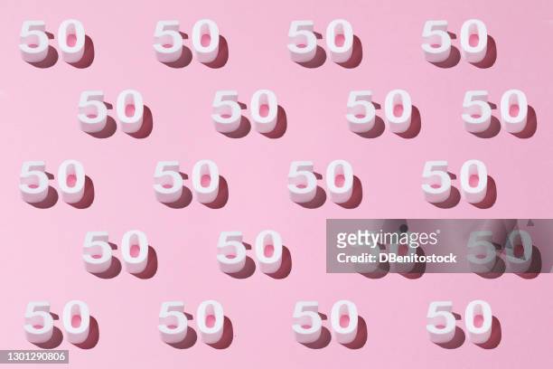 white pattern 50 on pink background. golden anniversary concept - 50th anniversary stock-fotos und bilder