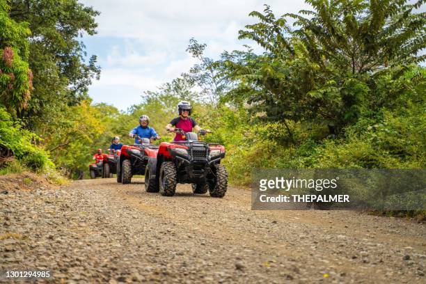 group of latin tourists driving a 4x4 bike in costa rica - atv riding stock pictures, royalty-free photos & images